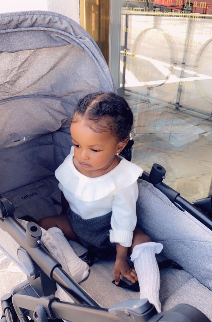Child sitting in a stroller with a blurred background